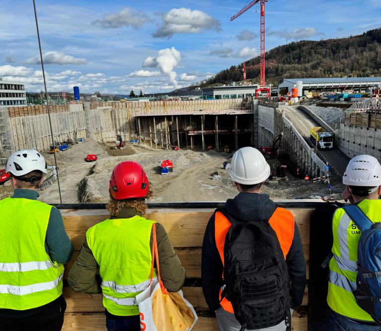 Baustelle im Hintergrund und vier Personen von hinten