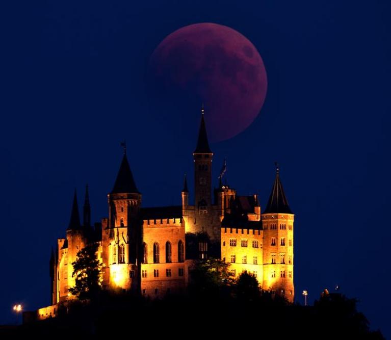 Mond als Blutmond am Himmel und Burg davor sch&ouml;n beleuchtet